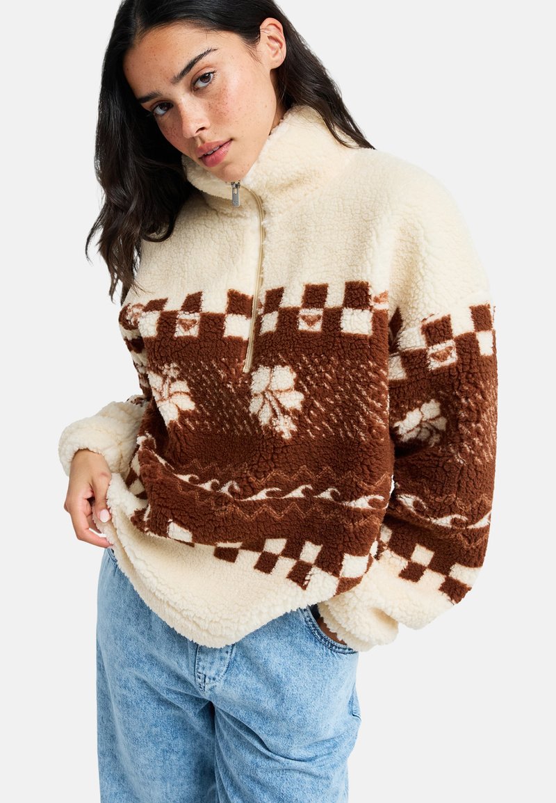 Pullover in pile a mezza zip di colore crema e marrone con un motivo a scacchi, dotato di un colletto alto e tessuto testurizzato per garantire calore.