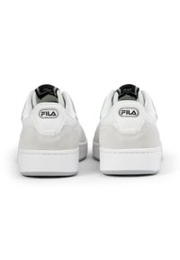 Sneakers bianchi con materiali in suede e pelle, punta rotonda, collo imbottito e dettagli del logo neri sul tallone. Suola in gomma bianca piatta.
