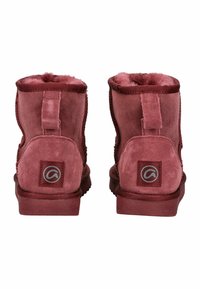 Stivaletti alla caviglia in suede bordeaux con una consistenza liscia, caratterizzati da una cucitura laterale e una patch con logo sul tallone. Fodera interna morbida visibile.