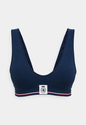 Navy blue bralette with a deep V-neck and wide straps, featuring a textured fabric and a logo patch with a crown on a contrasting band.