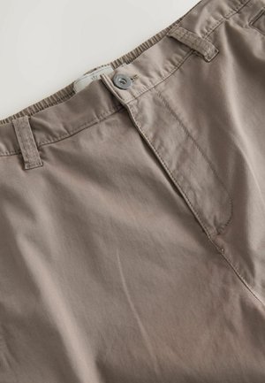 Pantalon en coton kaki avec fermeture à bouton, présentant une texture lisse, des poches inclinées et une taille soigneusement cousue.