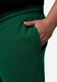 Groene joggerbroeken van een zachte katoenmix, met een geribde tailleband, zijzak en een subtiele reliëflogo-detail.}}