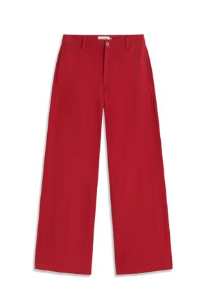 Pantalon rouge à jambes larges avec fermeture à bouton et fermeture éclair, passants pour ceinture et poches latérales, présenté à plat sur un fond blanc.