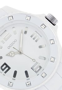 White silicone wristwatch with a round silver bezel, clear dial featuring silver hour markers, and crystal accents at 12, 3, 6, and 9 o'clock.