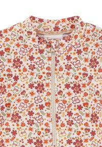 Blumenmuster-Reißverschlusskleidung in Hellrosa mit roten, orangefarbenen und grünen Blumen. Verfügt über einen hohen Kragen und eine glatte, weiche Textur.