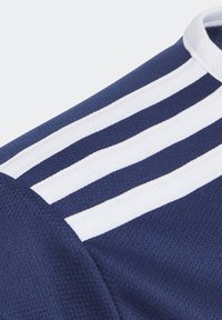 Tmavě modrý sportovní top s bílým designem tří pruhů. Vyrobený z texturované látky s kulatým výstřihem a švovými detaily.