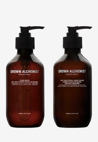 Bruna glasflaskor med svarta pumplock. Till vänster: handtvål, till höger: antibakteriell handkräm. Etiketter visar produktnamn och ingredienser.