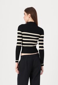 Μαύρος και κρεμ ριγέ πλεκτός σκούφος με μακριά μανίκια και υψηλή λαιμόκοψη, cropped σχέδιο, λεπτομερής ραφή και εφαρμοστή σιλουέτα.