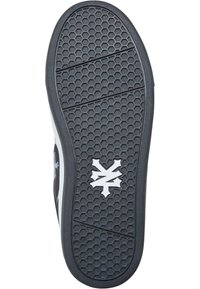 Sort gummierte såle med sekskantet grep, med en hvit logo i midten. Teksturert overflate for godt feste og holdbarhet.