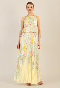 Faltendes Maxikleid in Pastellgelb, mit floralem Muster in Pink, Blau und Grün. Neckholder mit Details aus silbernem Metall.