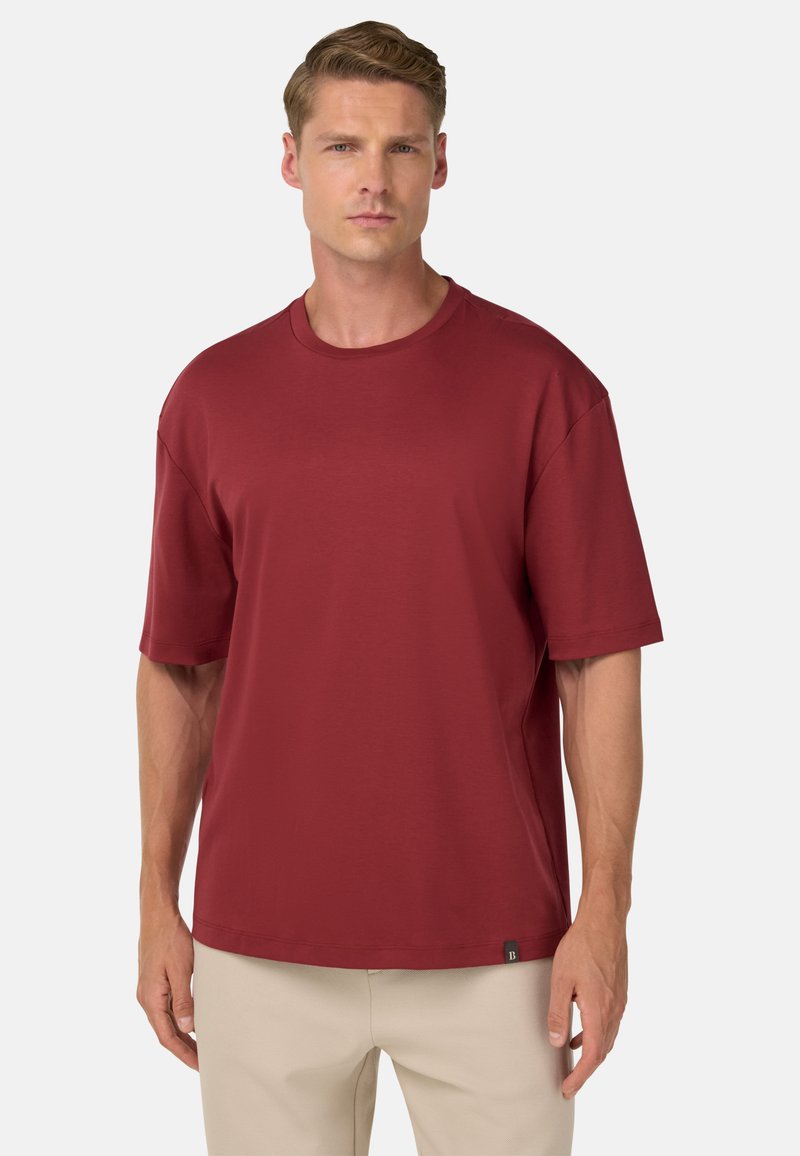 Rotes Kurzarm-T-Shirt aus weichem Material, mit Rundhalsausschnitt und lockerer Passform, versehen mit einem kleinen Logotag am Saum.