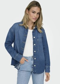 Spijkerblouse, middelblauw, met knopen, twee borstzakken, lange mouwen, rechte snit, zachte textuur en zilverkleurige hardware accenten.