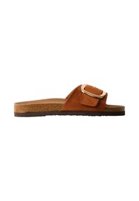 Sandale slide en daim marron avec une semelle intérieure en liège, une semelle noire et une grande boucle dorée sur la large bride supérieure.