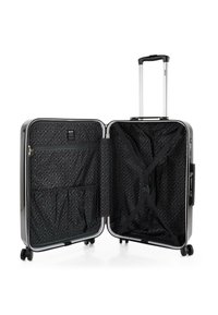 Maleta rígida con un exterior negro brillante, cremallera plateada, manija retráctil y cuatro ruedas. El interior cuenta con un tejido estampado y correas.