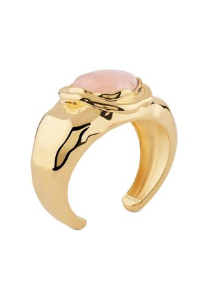 Bague déclarative de couleur dorée avec une finition lisse et polie, ornée d'une pierre ronde rose encastrée dans un design ondulé et surélevé.