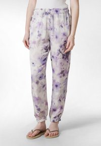 Lätta byxor med elastisk midja som har ett blommönster i lila och lavendelfärger, smalnade vid anklarna för en avslappnad passform.