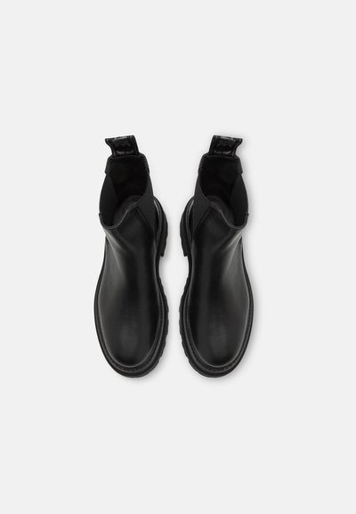Botines negros de tobillo hechos de cuero suave con puntera redondeada y paneles laterales elásticos. Cuenta con una lengüeta para facilitar el calzado. Suela de goma texturizada.