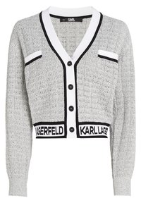 Szary dzianinowy kardigan z dekoltem w serek, białym kołnierzykiem, zapinany na guziki z przodu, z czarnymi akcentami. Posiada taśmę z logo przy dolnym brzegu i jedną kieszeń.