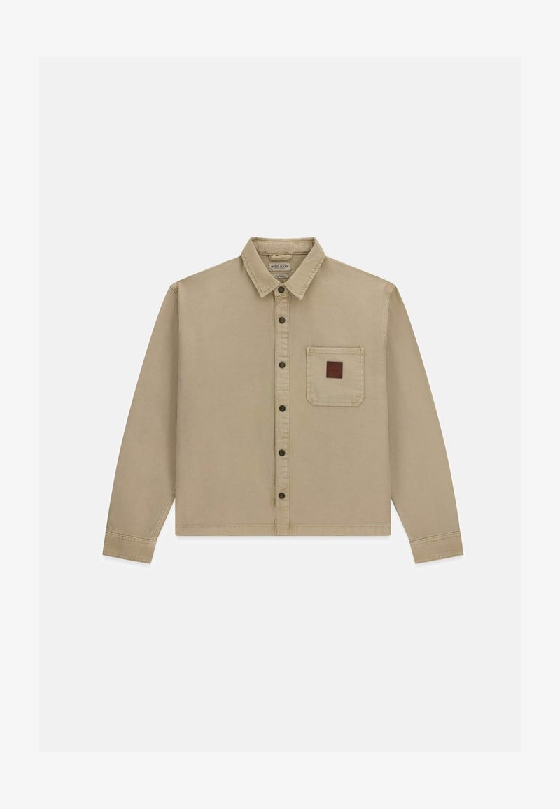 Chemise beige à manches longues boutonnée avec col et une seule poche poitrine avec un petit patch carré marron.