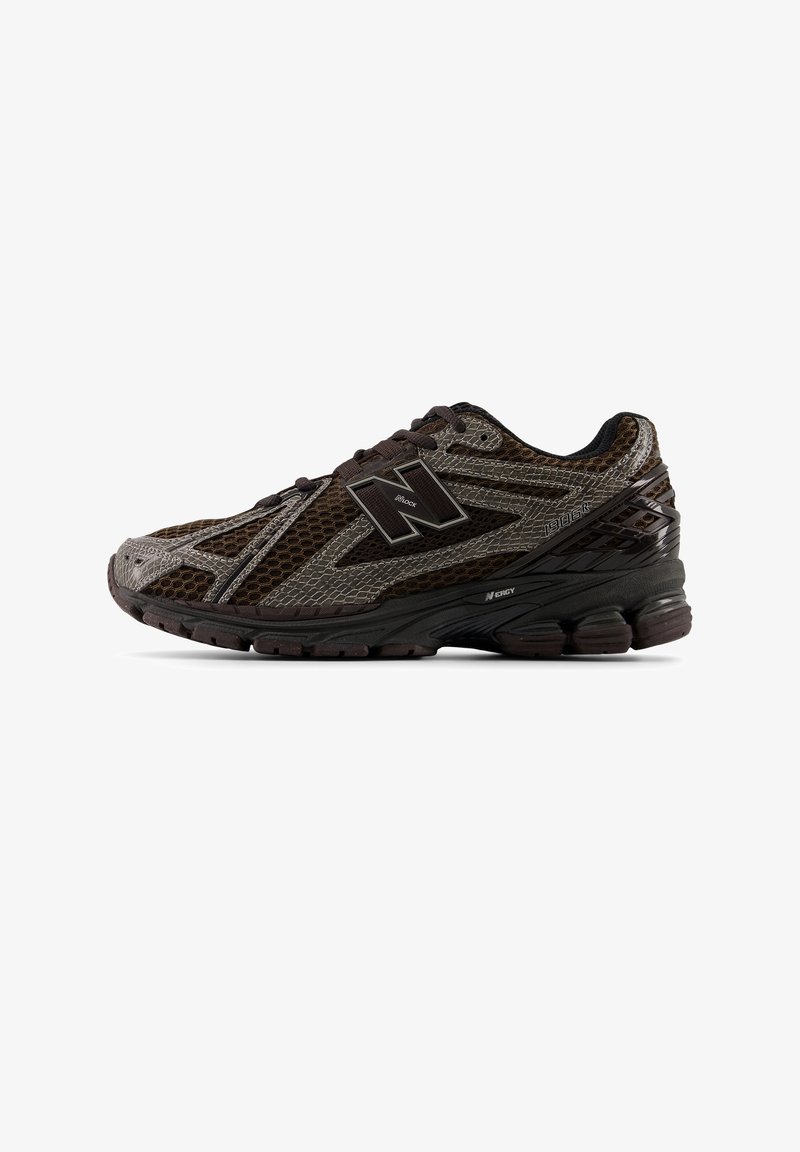 Chaussure de course New Balance marron foncé et noire avec tige en mesh, semelle épaisse et amortie, avec le logo "1906R" et "N-ERGY" sur le côté.