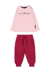 Chemise rose clair à manches longues avec impression noire "JOHN RICHMOND", associée à un pantalon de jogging bordeaux avec taille élastique et poches latérales.