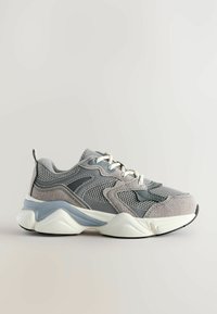 Szare siatkowe i zamszowe sneakersy z białą podeszwą środkową, zaokrąglonym czubkiem oraz kontrastującymi niebieskimi detalami, z szarymi sznurówkami i teksturowanymi akcentami.