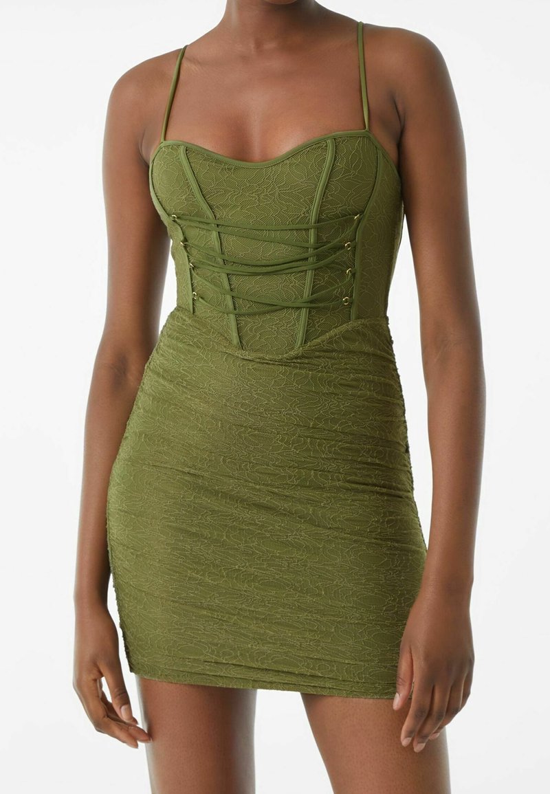 Zelené šaty z texturované tkaniny, s přiléhavým střihem, výstřihem ve tvaru srdce, tenkými ramínky a pérováním s zlatými akcenty.