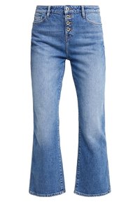 Blauwe spijkerbroek met uitlopende pijpen en een hoge taille, voorzien van vijf knopen, voorzakken en subtiele vervaging nabij de knieën.