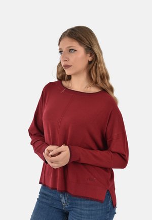 Maglione in maglia color bordeaux con scollo ampio e maniche lunghe, caratterizzato da polsini a costine e orlo con spacco laterale. Dettaglio logo discreto all'orlo.