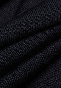 Tissu tricoté bleu marine foncé avec une texture lisse, présentant un motif à fines côtes. Le matériau semble doux et flexible.