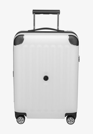 Valise rigide blanche avec des rainures verticales, poignée noire rétractable, accents en fibre de carbone et quatre roues. Présente le logo de la marque au centre à l'avant.
