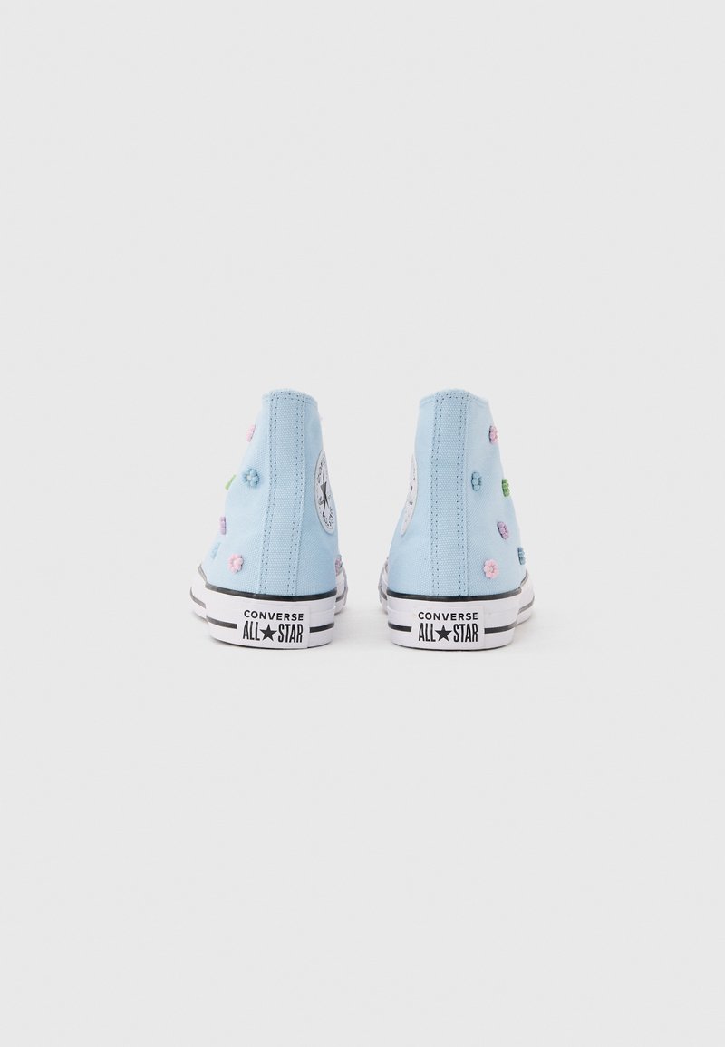 Scarpe da ginnastica Converse alte azzurro chiaro con fiori pastello ricamati, viste da dietro su uno sfondo bianco.