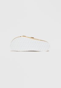 Η σόλα του παπουτσιού έχει καφέ χρώμα με δύο ρυθμιζόμενες λουρίδες και μια λευκή υφασμάτινη εξωτερική σόλα από καουτσούκ. Λείο φινίρισμα με ελαφριά καμπύλη.