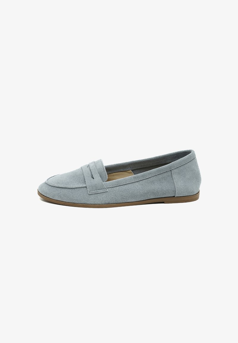 Mocassins en suede bleu clair avec une semelle plate et flexible, dotés d'une bandoulière cousue sur le devant et d'une doublure intérieure lisse.