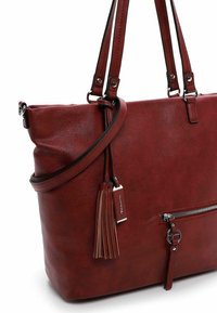 Borsa a mano in pelle rossa con manici doppi e una tracolla regolabile. Presenta una tasca frontale con zip e un dettaglio decorativo a nappina.