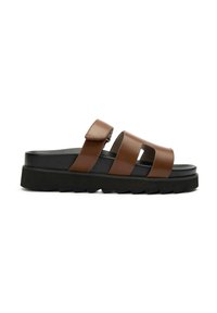 Brown leather slide sandal with two wide straps and adjustable buckle, featuring a chunky black sole with a textured surface.