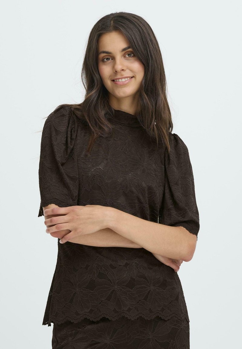 Brun blonde top med puf korte ærmer, høj halsudskæring, blomster mønster, bølget kant og en struktureret overflade.