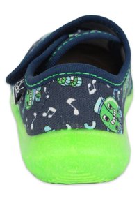 Kinderschoen met een marineblauwe bovenkant van stof, versierd met groene monsterpatronen en muzikale noten, aangevuld met een felgroene rubberen zool.