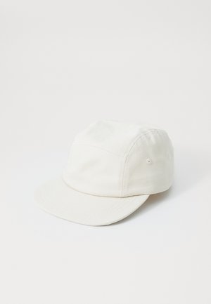 White cap made of cotton, featuring a low profile design, a curved brim, and vent holes on the sides for breathability.