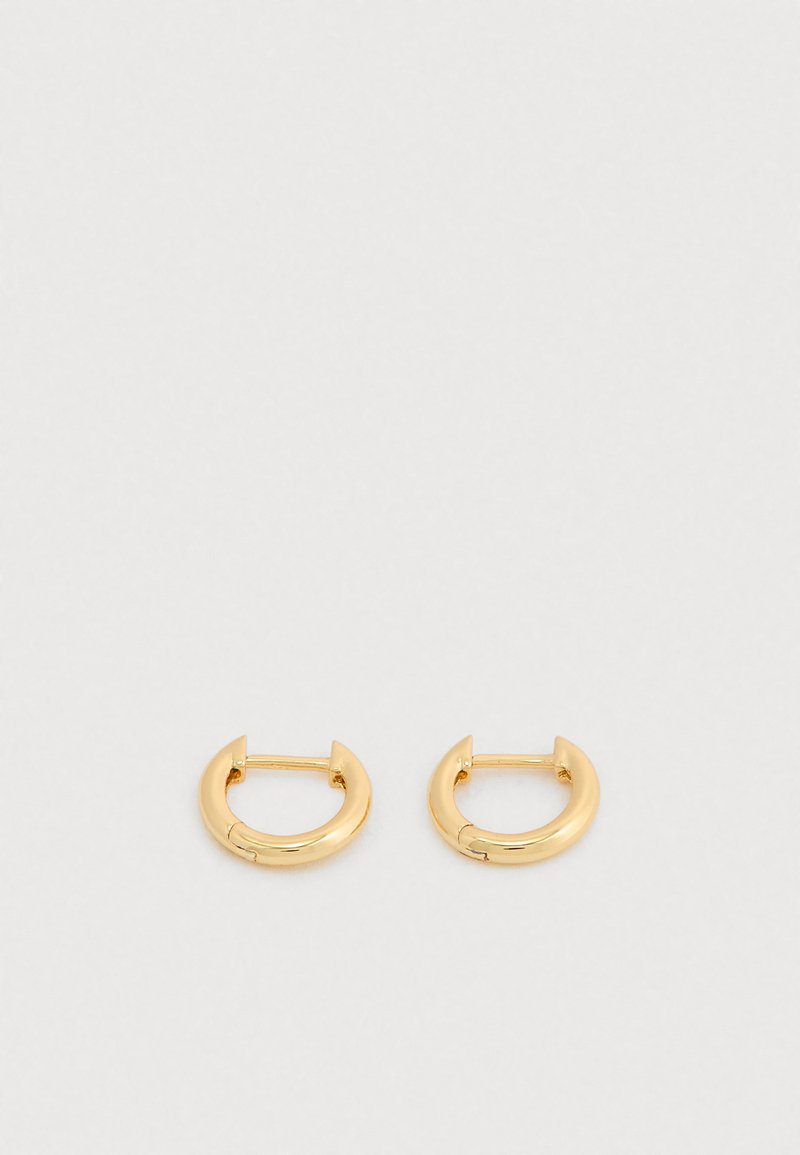 Zlaté kruhové náušnice s hladkým, lesklým povrchom. Majú kruhový tvar s malým otvorom na zatváranie. Jednoduchý dizajn, minimálne zdobenia.