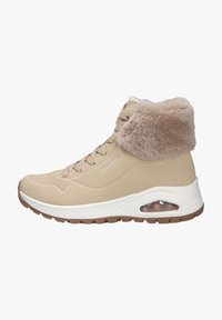 Sneaker alta beige con risvolto in pelliccia, allacciatura frontale, suola bianca con imbottitura e tasca d'aria visibile, e suola esterna marrone texturizzata.