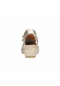 Metallisch gouden espadrille sandaal met een geweven jute hak, open achterkant en twee decoratieve bandjes. Gladde textuur met een gevoerd voetbed.