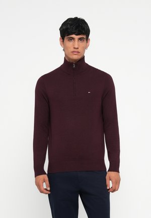 Burgundy zip-neck sweater in a fitted design, made from a smooth knit fabric. Features ribbed cuffs and hem with a small logo detail on the chest.