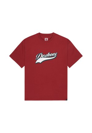 Rotes Baumwoll-T-Shirt mit dem "DC Shoes"-Logo in Weiß und Blau in Kursivschrift, Rundhalsausschnitt, kurzen Ärmeln und geradem Saum.