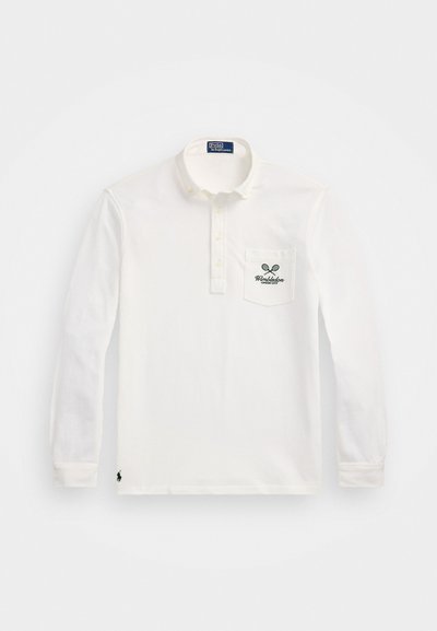 Polo alb cu mânecă lungă, din bumbac, având o închidere cu nasturi și un buzunar pe pieptul stâng cu un logo verde Wimbledon.