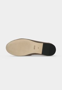 Semelle d'une chaussure marron avec l'avant de la semelle beige clair, le talon noir, et le texte "BOSS 37" imprimé au centre sur un fond uni.
