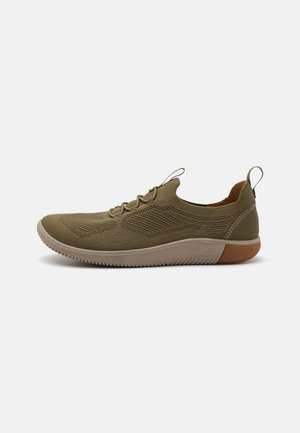 Leichtgewichtige olivgrüne Sneaker mit einem atmungsaktiven Mesh-Obermaterial, strukturiertem Design, elastischen Schnürsenkeln und einer flexiblen beigen Sohle mit braunen Akzenten.