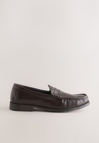 Mocassin homme en cuir marron foncé avec bout arrondi, petit talon et détail sangle sur le dessus, vu de côté sur fond neutre.