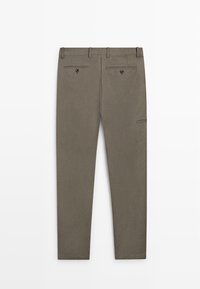 Brązowe, dopasowane spodnie z pętelkami na pasek, dwoma zapinanymi na guziki tylnymi kieszeniami oraz małą boczną kieszonką na prawej nodze, ułożone płasko na białym tle.