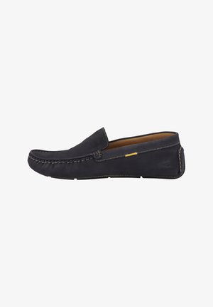 Musta nahkainen slip-on-loafer näkyvillä saumoilla ja vaaleanruskealla sisäpuolella, nähtynä sivulta valkoisella taustalla.